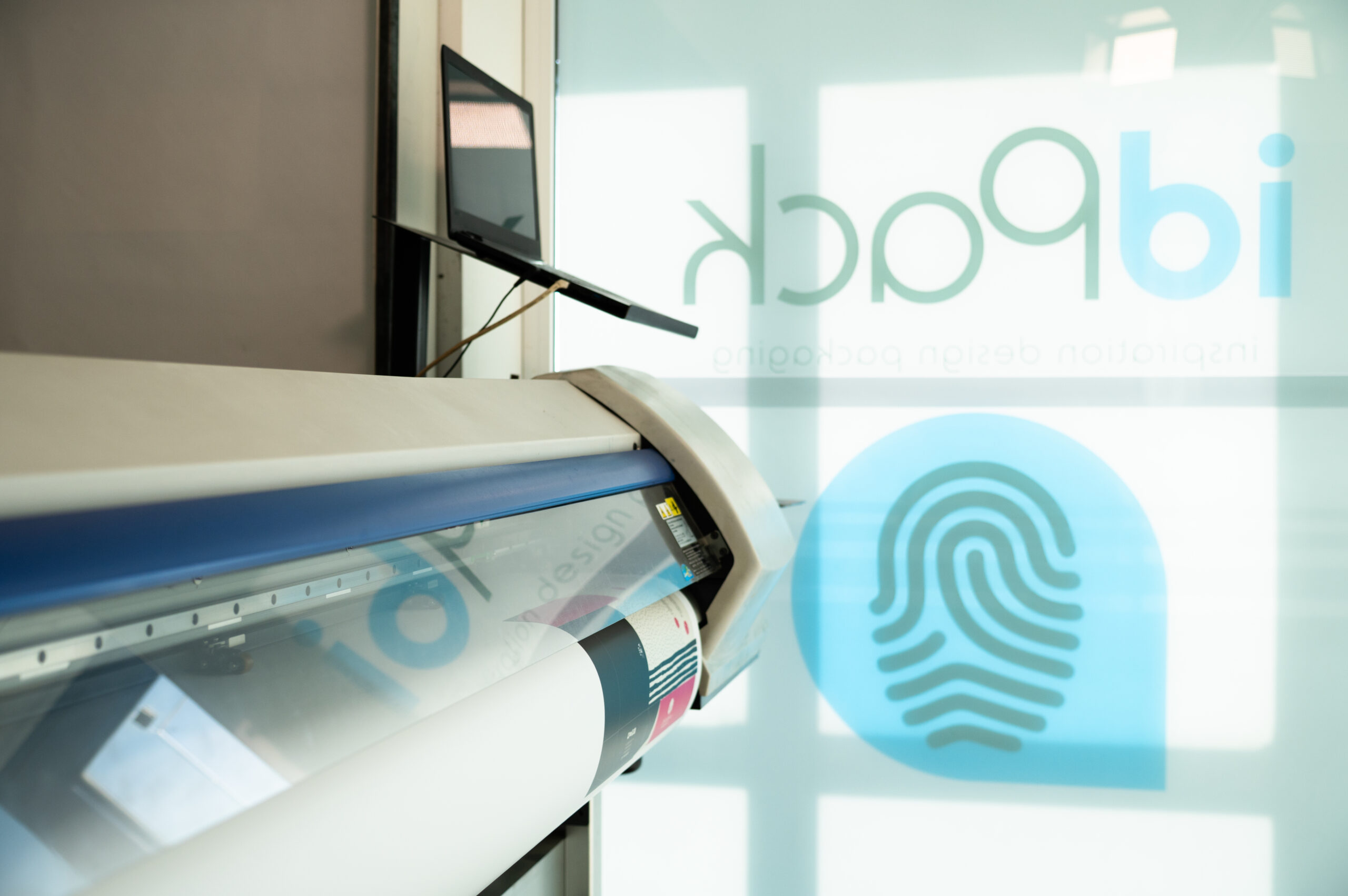 A plotter in a room with the logo of idPack